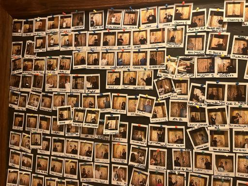 Eine Wand mit vielen Polaroid-Fotos, die eng nebeneinander angeordnet sind.