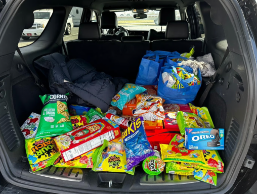 Voller Kofferraum mit Snacks, Süßigkeiten und Getränken in bunten Verpackungen.