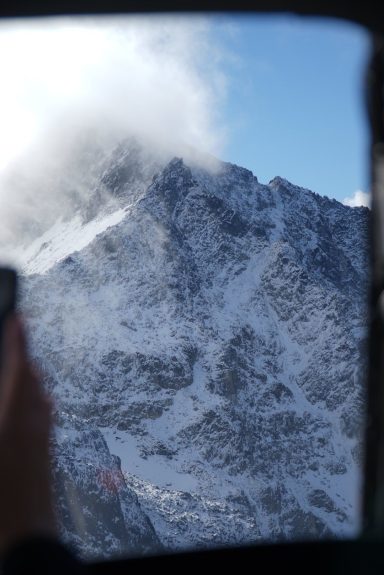 Berglandschaft mit schneebedeckten Gipfeln und Wolken im Hintergrund.