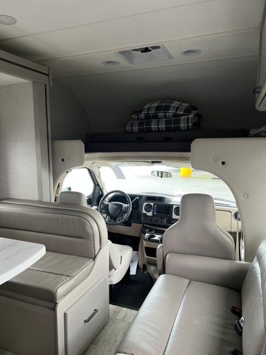 Moderne Wohnmobil-Innenausstattung mit Fahrersitz und Wohnbereich.