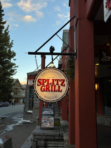 Schild des Splitz Grill mit leuchtenden roten Buchstaben an einem Geschäft.
