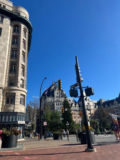 Städtische Straße mit historischem Gebäude, modernen Verkehrsampeln und klarem Himmel.