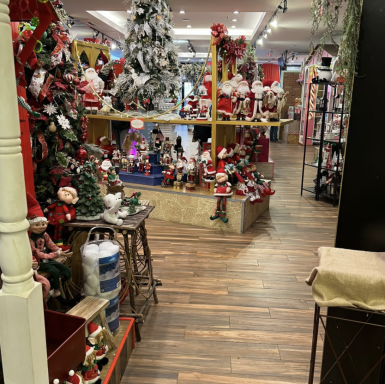 Weihnachtlich dekorierter Laden mit Bäumen, Figuren und festlicher Beleuchtung.