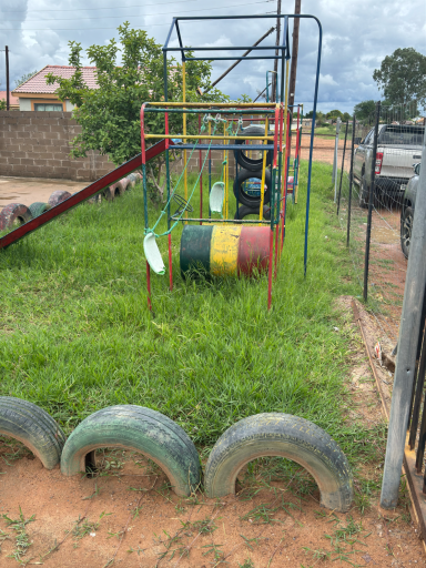 Bunte Reifen-Spielgeräte in einem grünen, unebenen Garten.