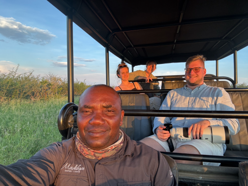 Gruppenausflug im Geländewagen, vier Personen in der Natur, sonnenuntergangsähnliches Licht.