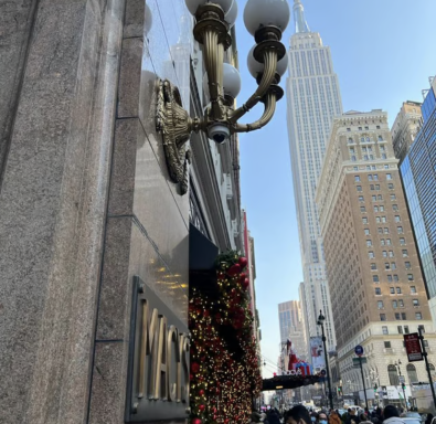 Weihnachtsdekoration am Gebäude mit dem Empire State Building im Hintergrund.