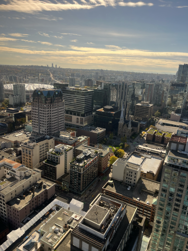 Blick auf eine Stadtlandschaft mit Wolkenkratzern und einer weiten Skyline im Hintergrund.
