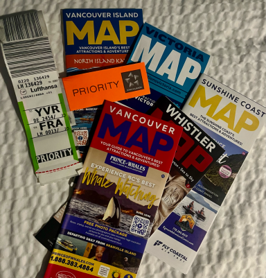 Diverse Karten und ein Ticket für Vancouver, auf einem hellen Hintergrund angeordnet.